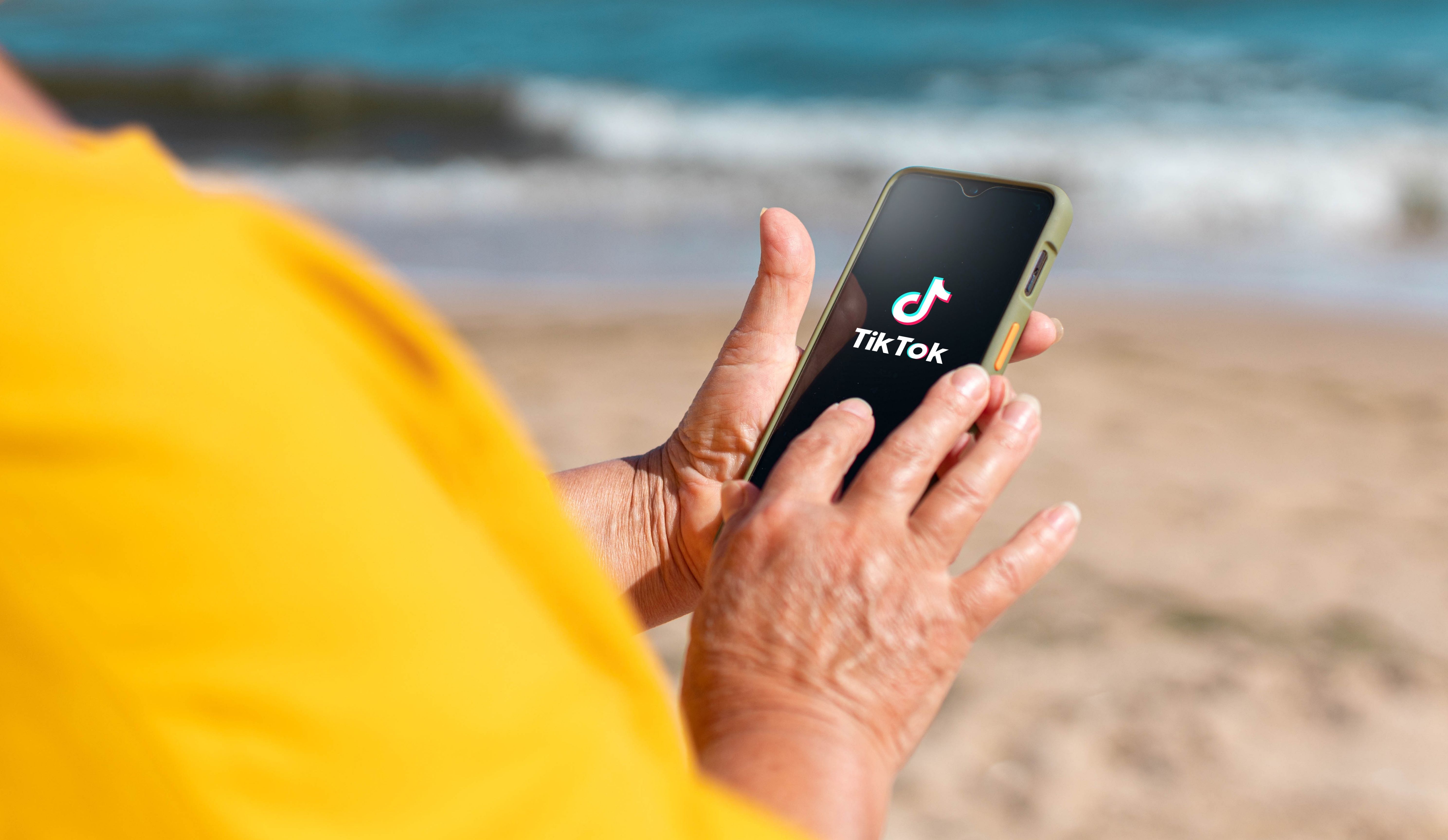 Une femme qui regarde TikTok sur son téléphone.